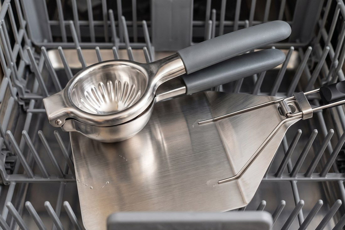 The stainless lemon squeezer and the steel pizza peel blade in a dishwasher basket, no wood or bamboo among them