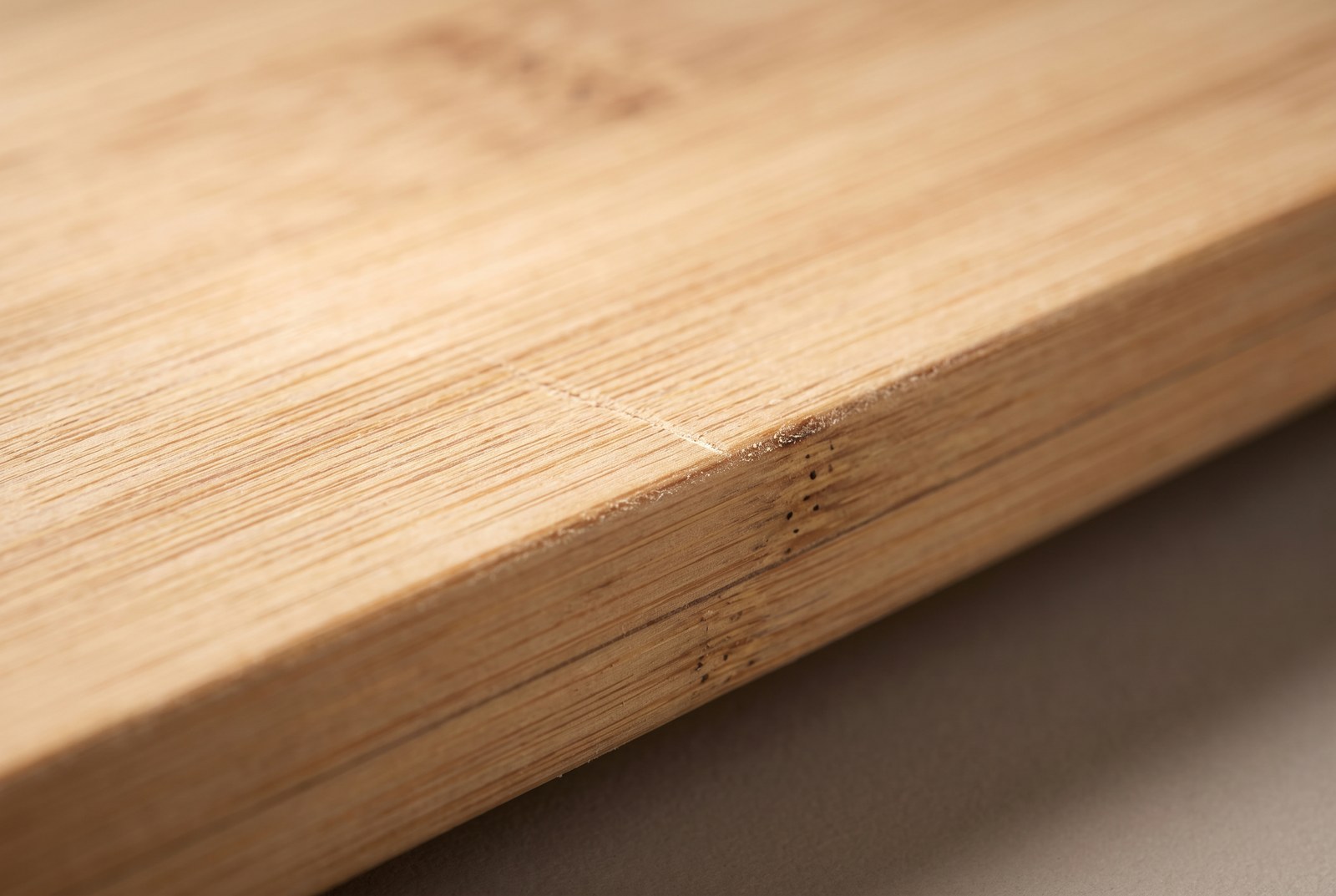 Macro of the cut edge of a solid bamboo board showing its fibres and glue lines